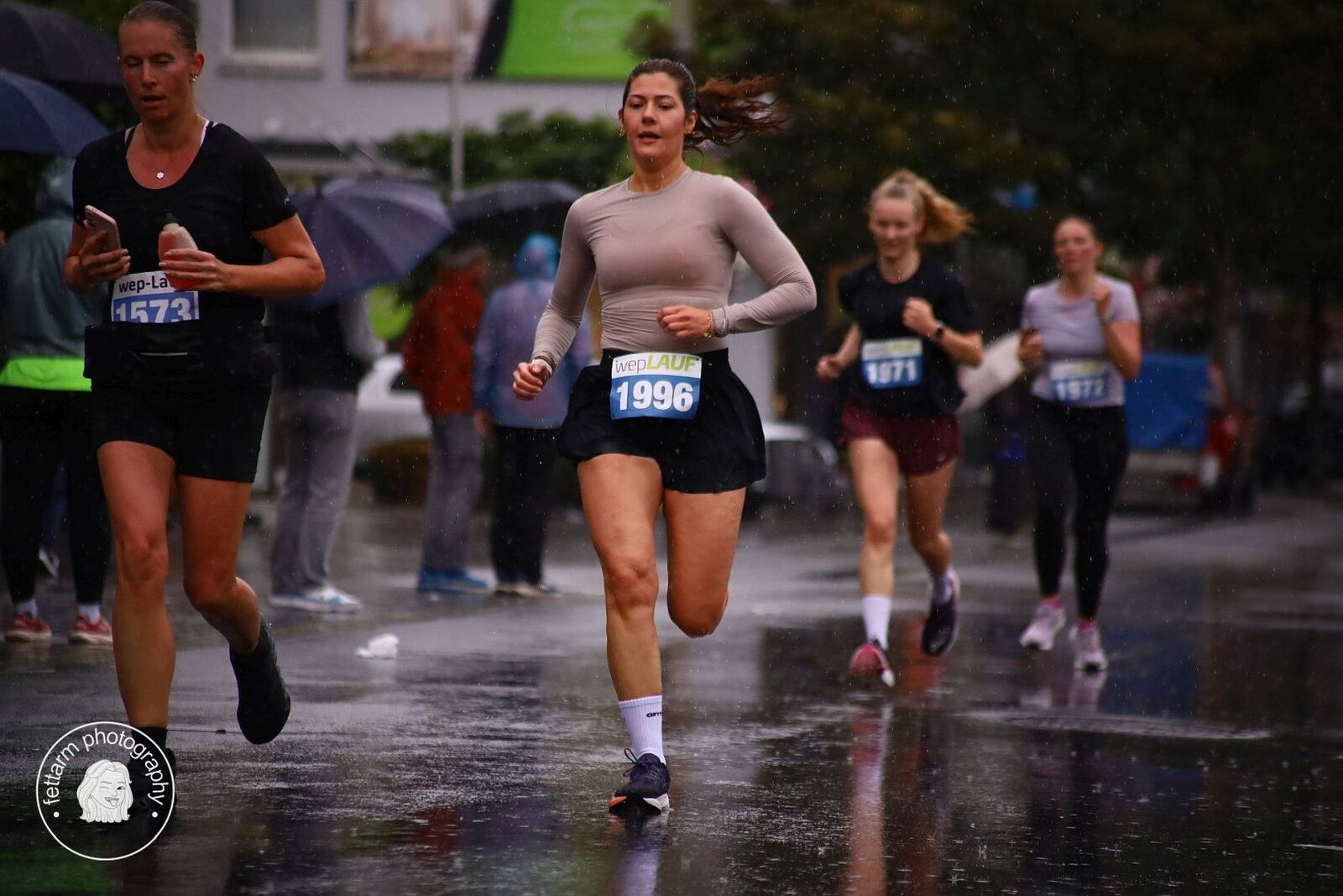 Läuferinnen im Regen auf der Innenstadtrunde, vorne Startnummer 1996
